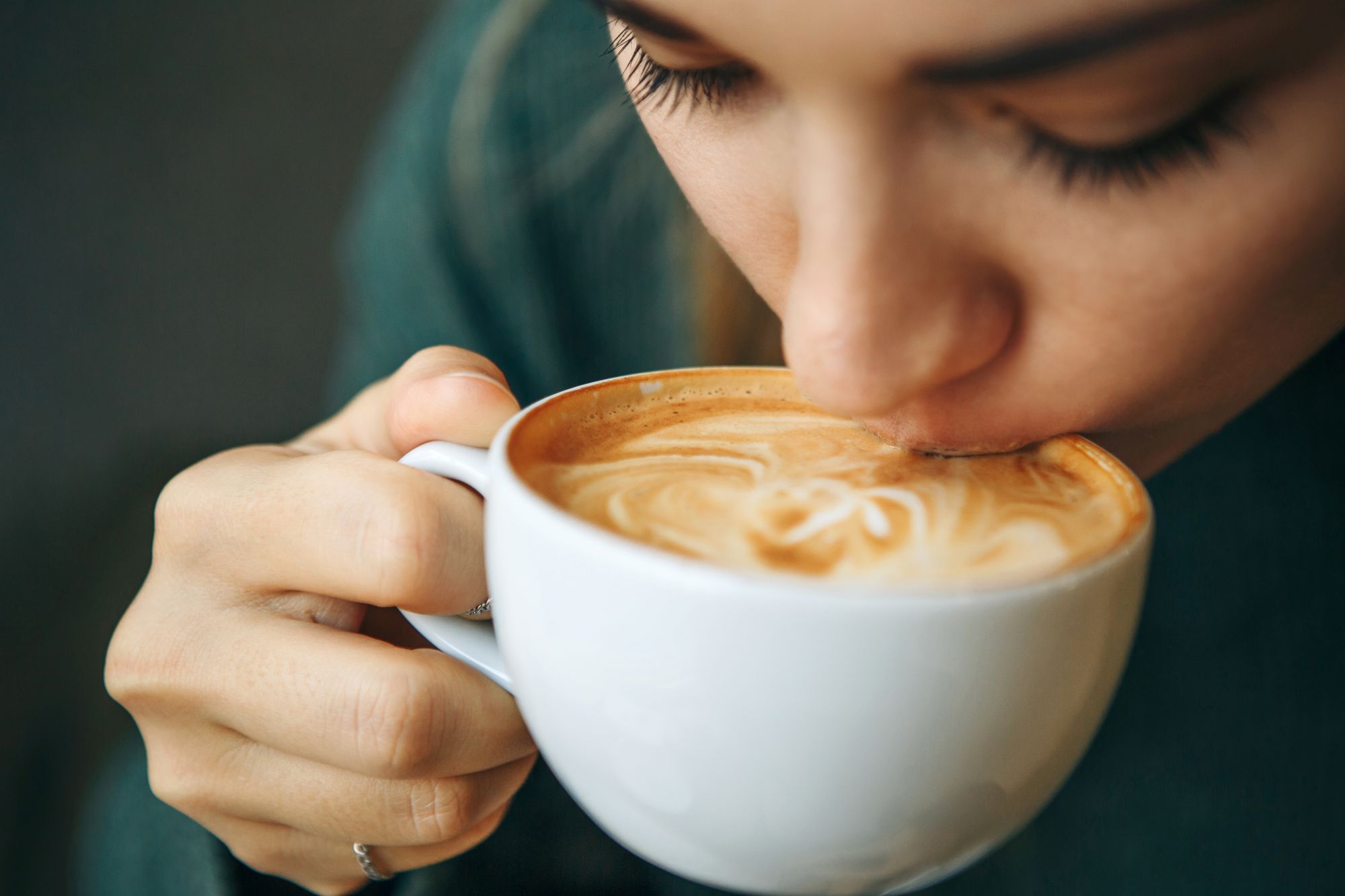 Una chica bebe café de una taza.
