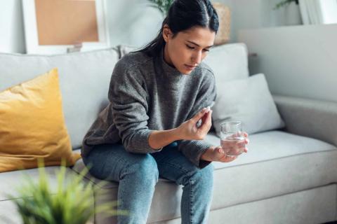 Woman with a tablet and a glass of water.