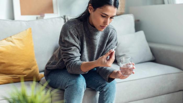 The most effective strategy for discontinuing antidepressants is gradual reduction combined with psychological therapy, according to data from more than 17,000 adults Woman with a tablet and a glass of water.