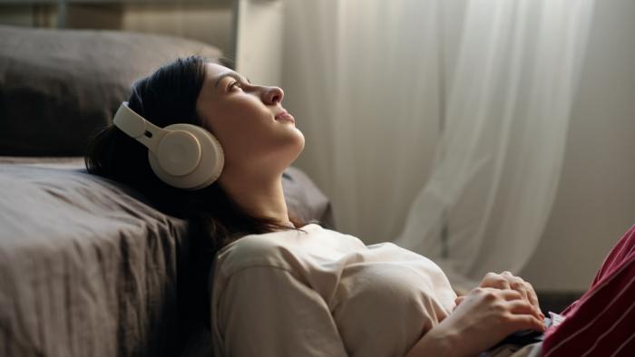 Las letras pop cada vez hablan más de estrés y son más negativas, excepto en momentos de crisis social Chica escuchando música con auriculares.